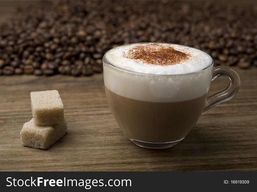 Cup of cappuccino on coffee beans background