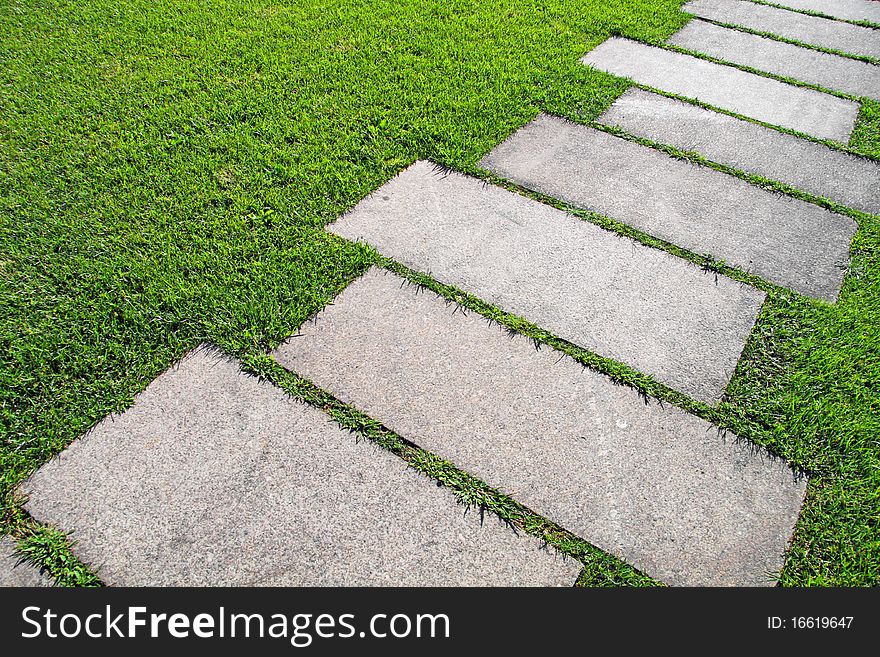 Detail of a pavement path going through the grass. Detail of a pavement path going through the grass