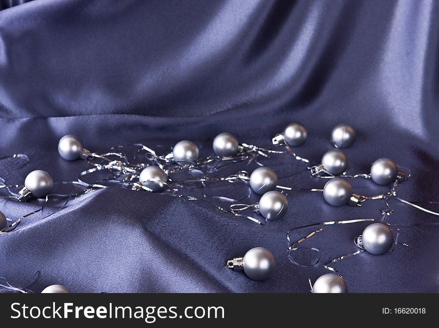 Satin background with Christmas decorations; small DoF, focus on base