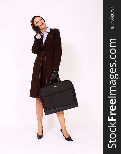 Business woman talking on the cell phone holding briefcase