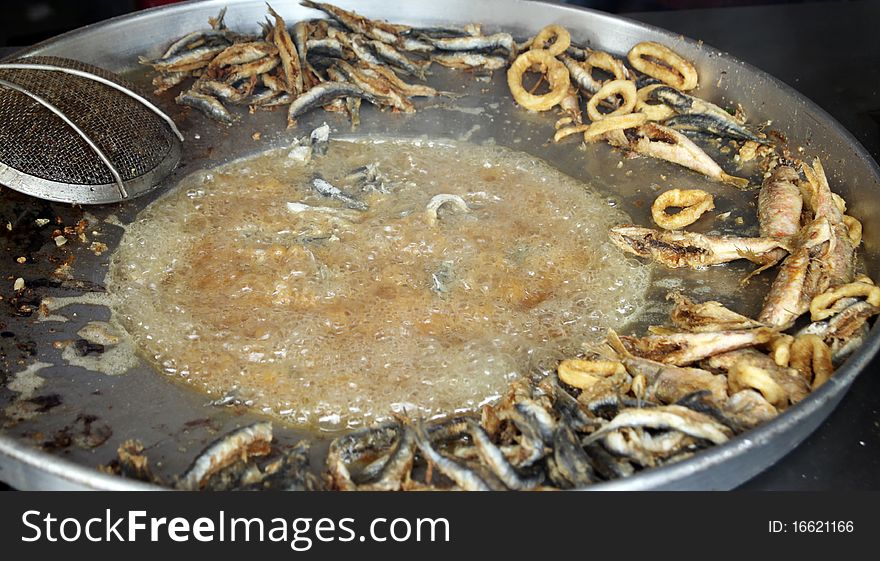 A view of fried fish. Anchovy, bluefin and frier.