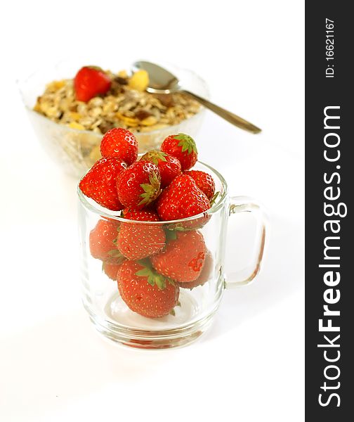 Strawberry in glass and muesli isolated on white