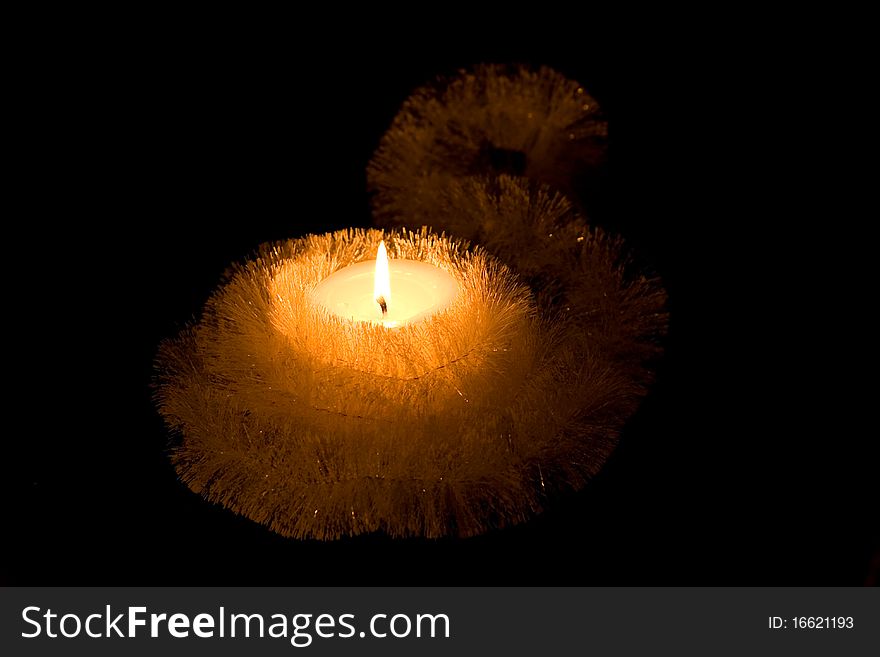 Christmas Candle. Small candle with bright glowing flames on a black background. Christmas Candle. Small candle with bright glowing flames on a black background.