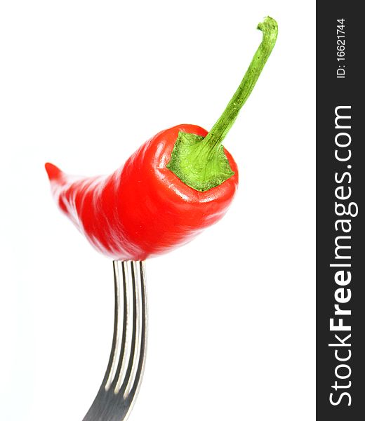 Red chili pepper on a fork isolated on white