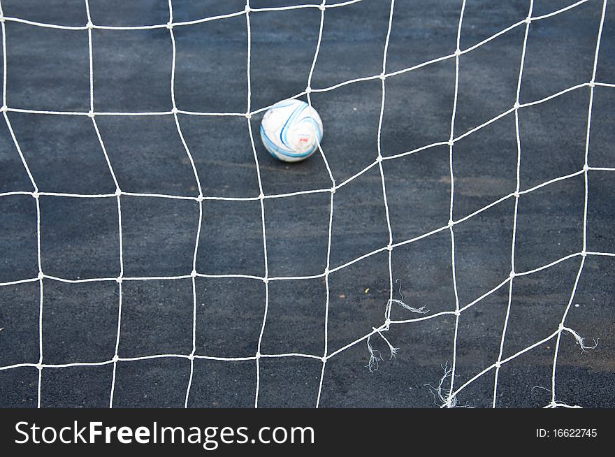 Goal net and football in the park