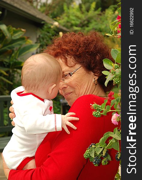 A grandmother in striking red with her grandbaby