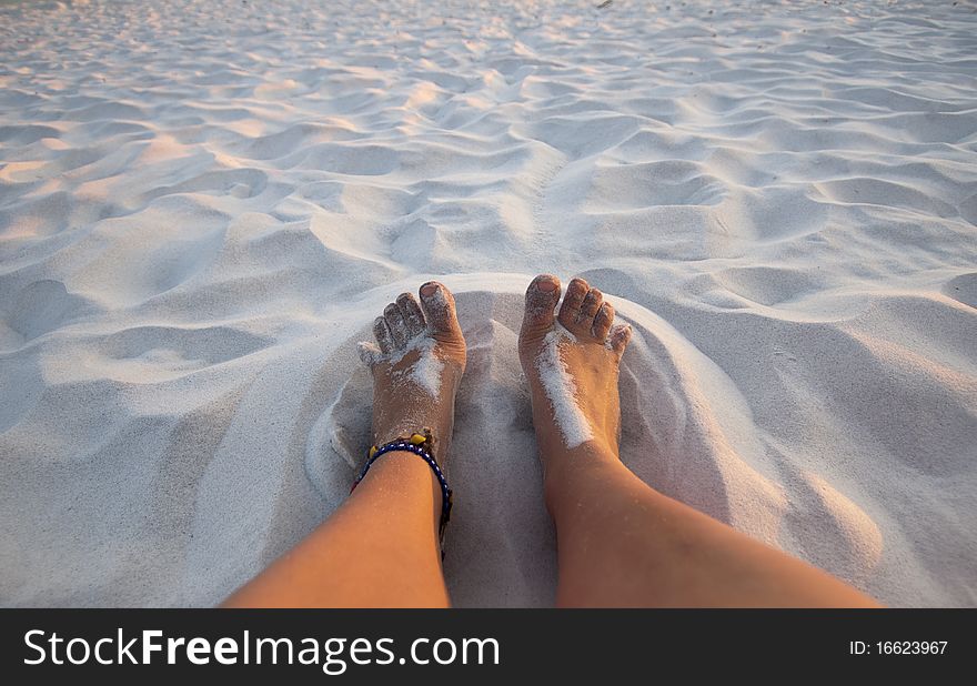 Feet playing in the sand on a white sand beach. Feet playing in the sand on a white sand beach