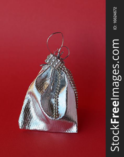 Packaging made from silver fabric for jewelry on a red background. Packaging made from silver fabric for jewelry on a red background