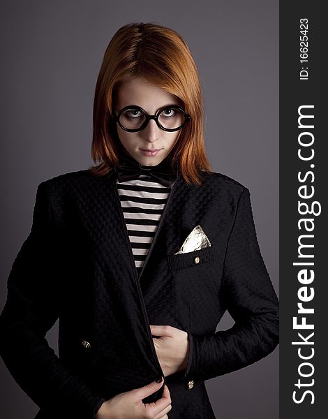 Portrait of fashion girl in jacket and glasses. Studio shot.