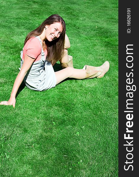 Happy Young Brunette On The Green Grass