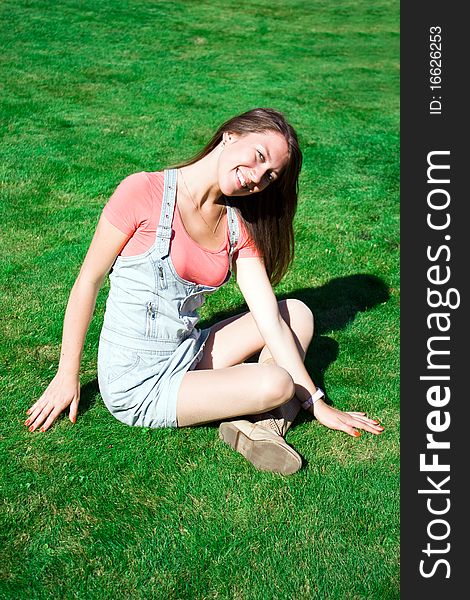 Beautiful Healthy Young Woman Sitting On Grass