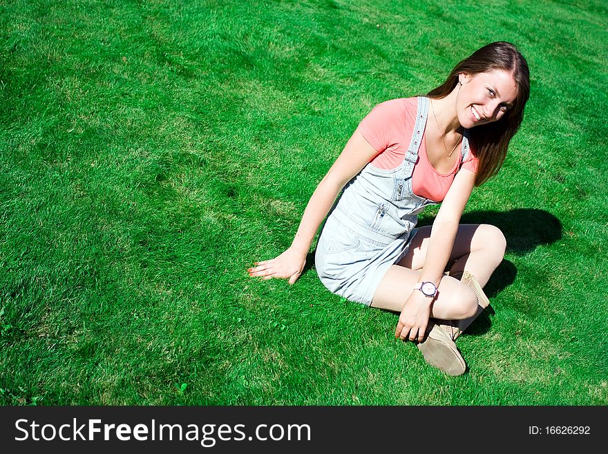 Cute Brunette On The Green Grass In Summer