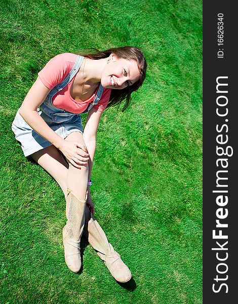 Happy Young Brunette On The Green Grass