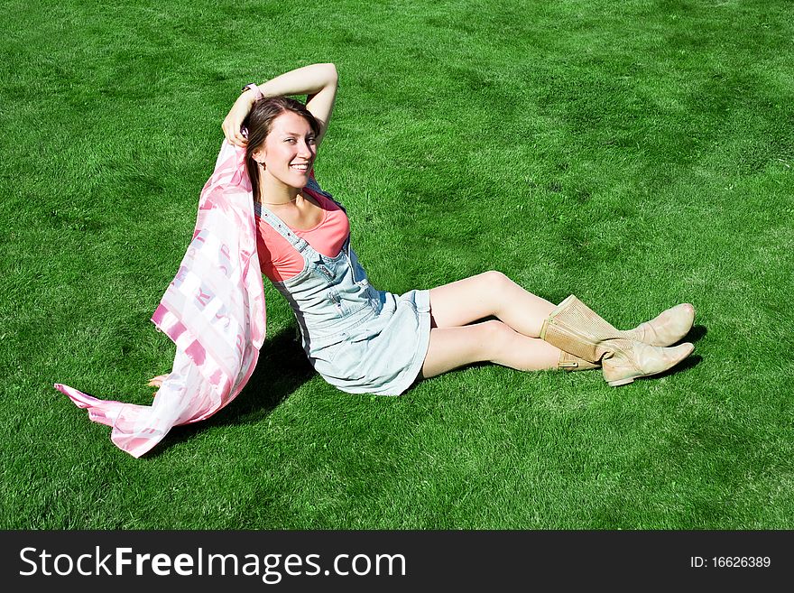 Happy young brunette on the green grass. Happy young brunette on the green grass