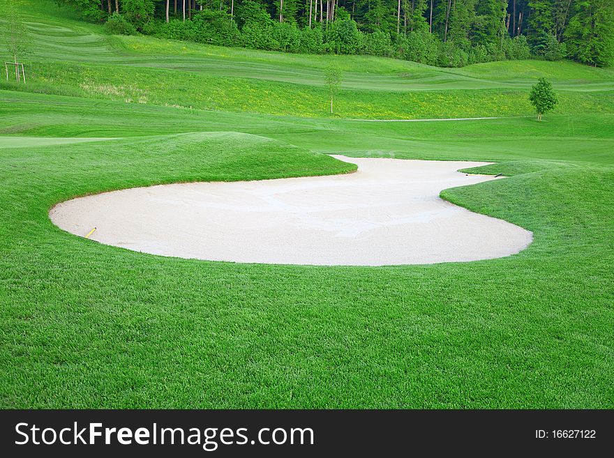 Golf: sand trap on the green grass