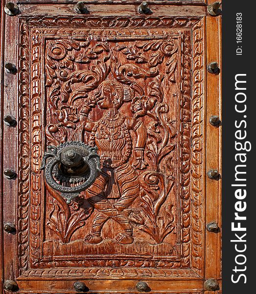 Very old wood panel carved in low relief with an absolutely beautiful door knocker bronze-green. Very old wood panel carved in low relief with an absolutely beautiful door knocker bronze-green