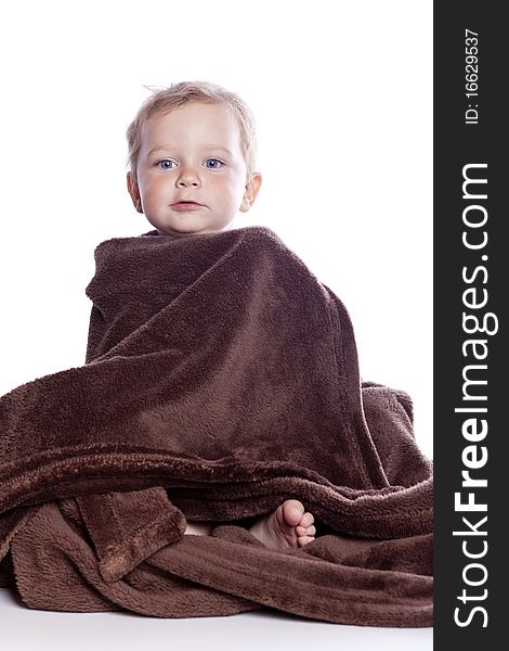 Beautiful baby under a brown towel on white