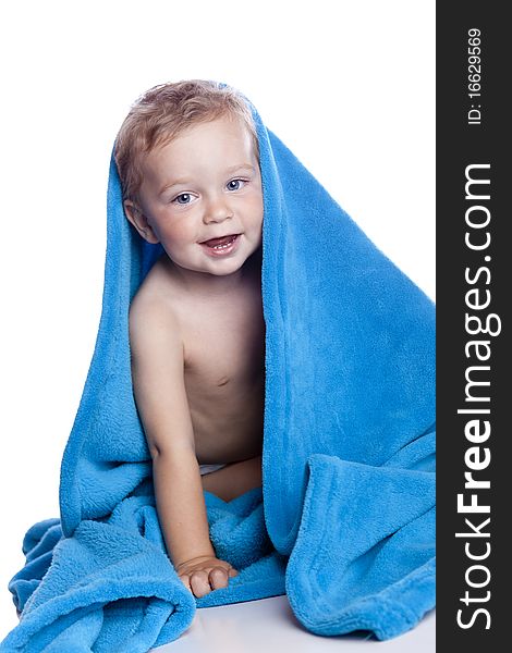 Beautiful baby under a blue towel on white. Beautiful baby under a blue towel on white