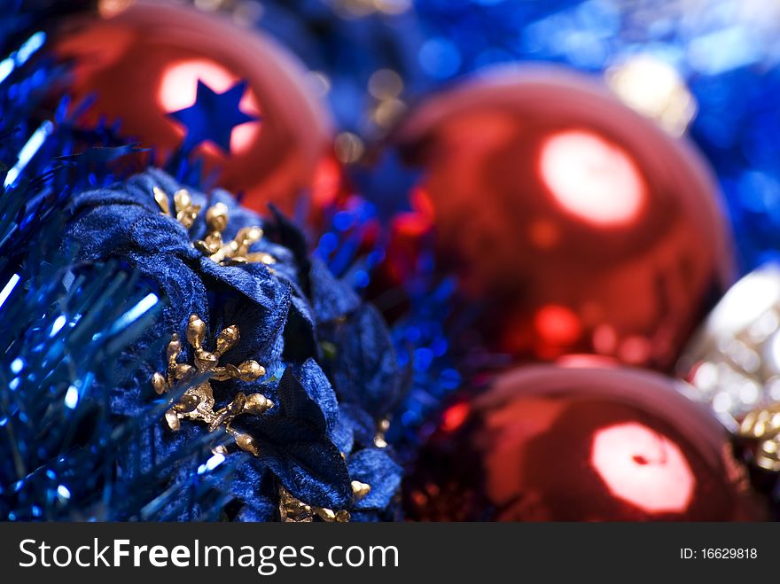 Red Christmas ball with blue decorative flowers and tinsel close-up. Red Christmas ball with blue decorative flowers and tinsel close-up