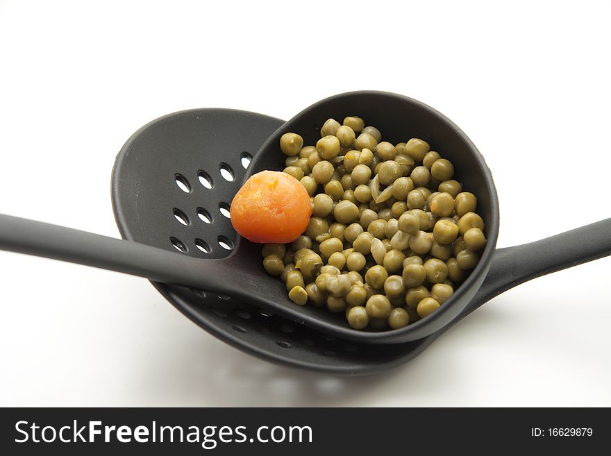 Ladle with cooked peas and carrot. Ladle with cooked peas and carrot