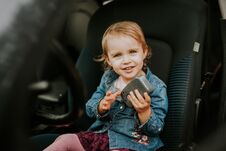 Little Girl In A Car Seat. Holding Phone In Her Hand. Taking Driver Seat. Car Damage. Authentic Image Stock Photos