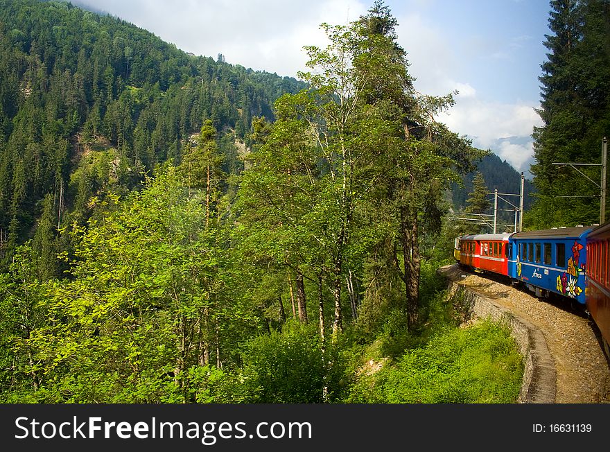 View of a train passing through the Swiss countryside. View of a train passing through the Swiss countryside