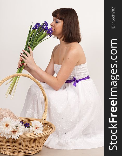 Beautiful girl with Irises and a basket of flowers