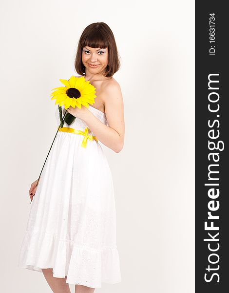 Beautiful girl smiling and holding a sunflower - isolated over a white background. Beautiful girl smiling and holding a sunflower - isolated over a white background