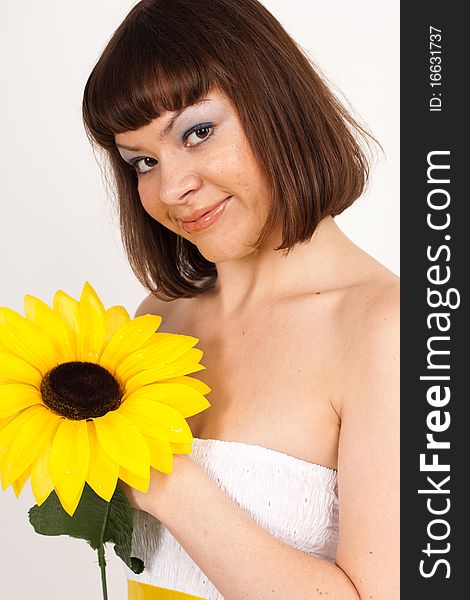 Beautiful girl smiling and holding a sunflower - isolated over a white background. Beautiful girl smiling and holding a sunflower - isolated over a white background