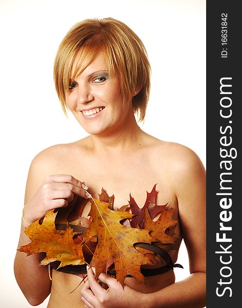 Young woman having fun at the autumn leaves