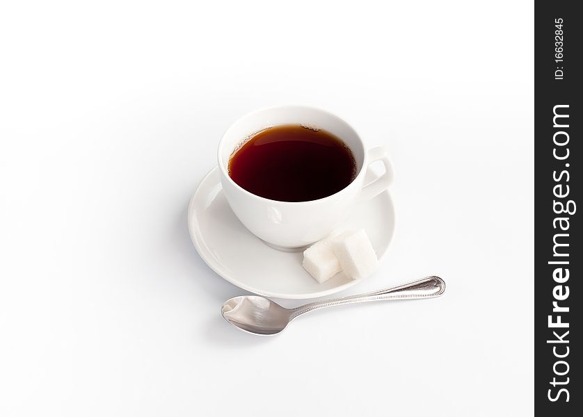 Cup of black tea with sugar and spoon isolated on white