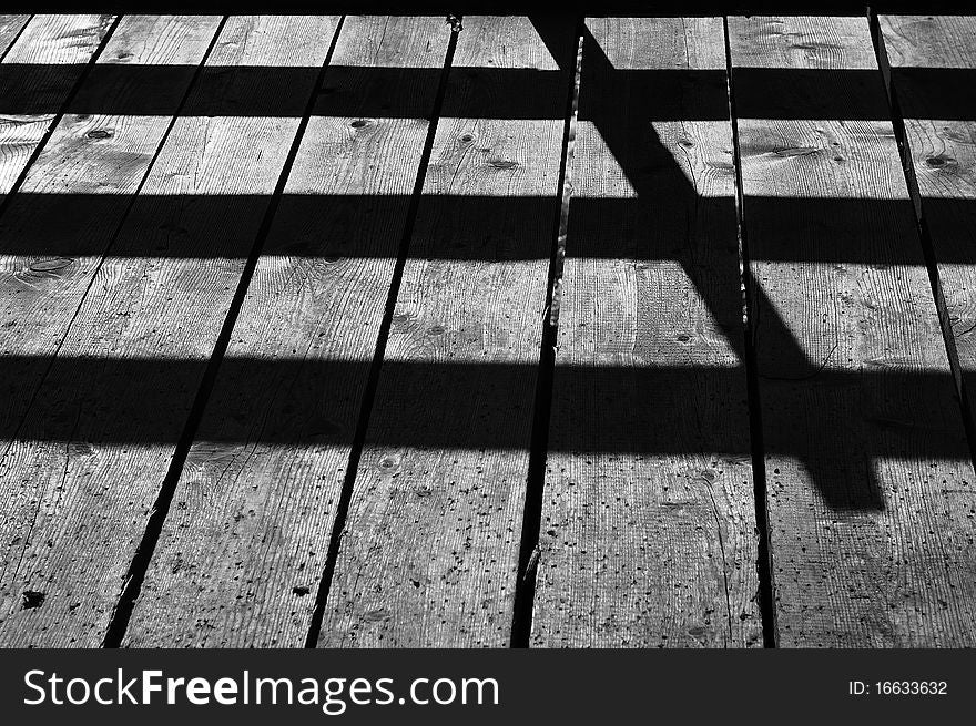 Weathered aged wooden plank with shadows on it.