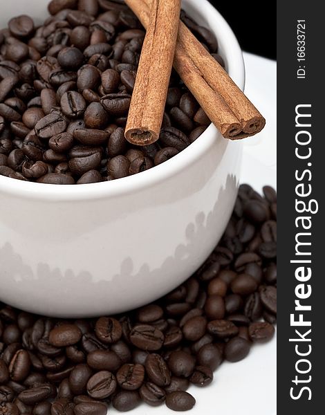 Coffee cup with coffee beans and cinnamon sticks