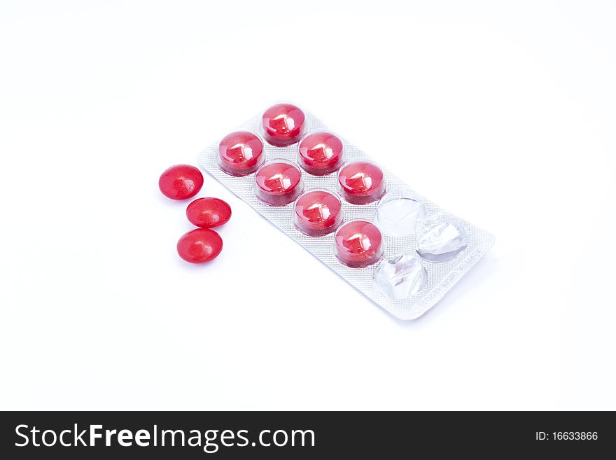 Red pills packed in blister isolated on white