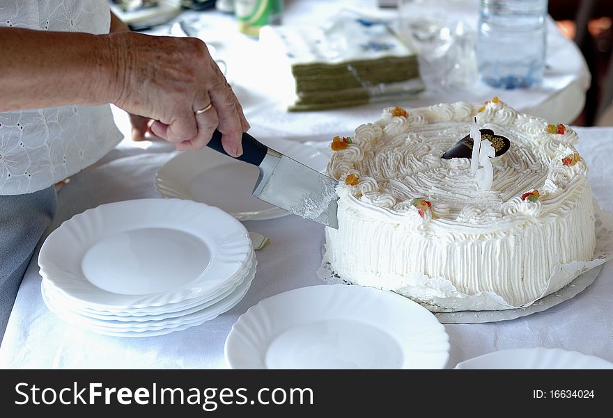 Old lady cutting birthday cake.