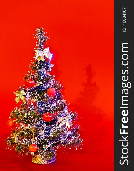 Christmas tree is richly decorated with a red background