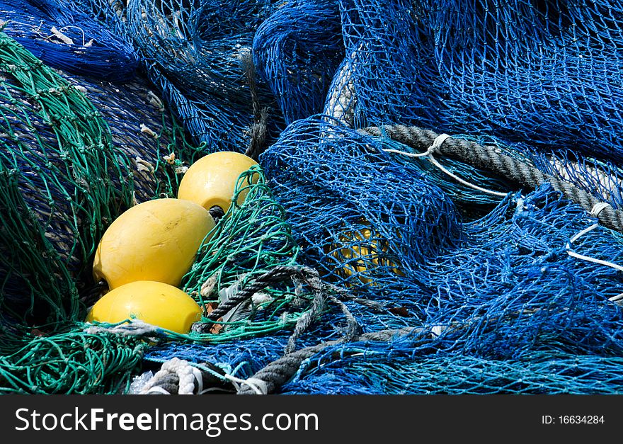 Close-up of blue and emerald green fishing nets and yellow floats. Close-up of blue and emerald green fishing nets and yellow floats