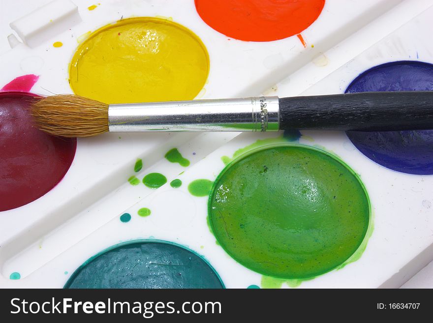 Dirty watercolor paints set with brushes after using. Dirty watercolor paints set with brushes after using