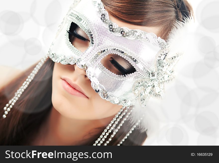 Wearing a glamour white party mask with closed eyes. Wearing a glamour white party mask with closed eyes