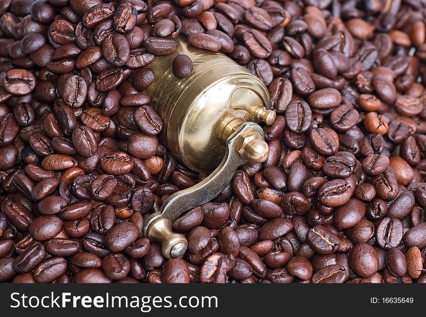 Coffee grinder on coffee grains close up