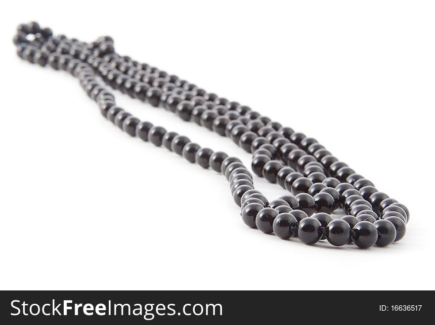 Black isolated beads over white background. Image.