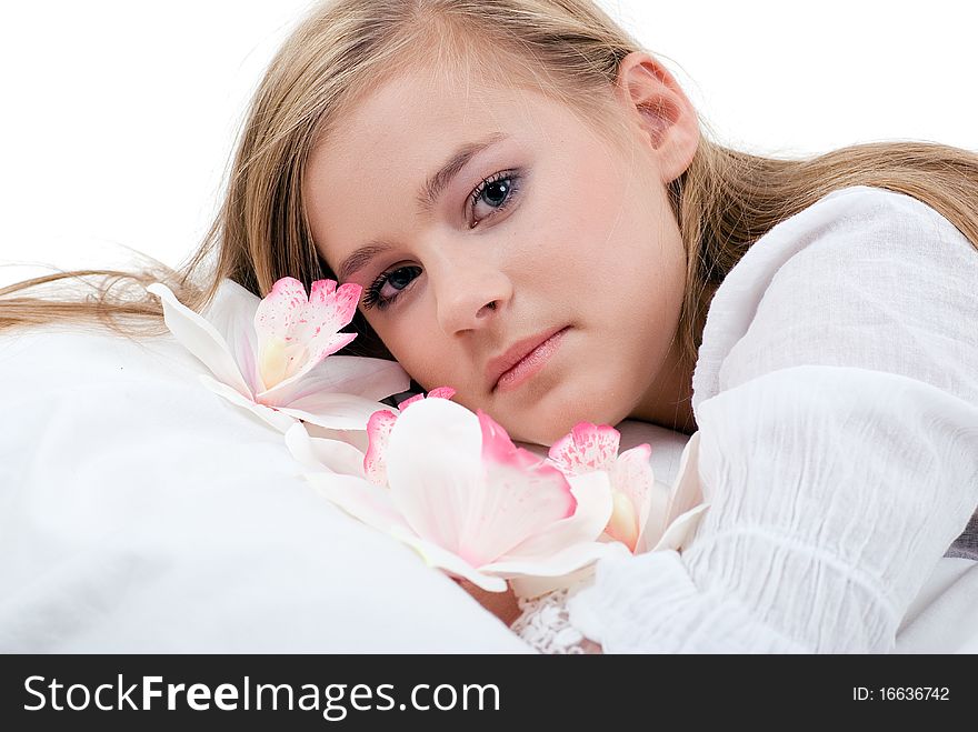 Portrait of a lying girl with long blond hair with white orchids. Portrait of a lying girl with long blond hair with white orchids.