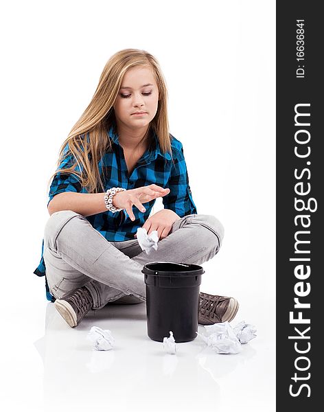 Teenage girl is sitting and throwing rubbish into the garbage. Teenage girl is sitting and throwing rubbish into the garbage.