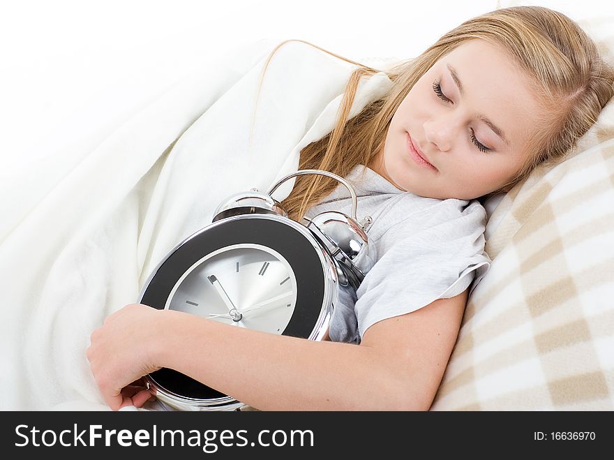 Young girl fell asleep with her alarm clock. Studio shot on a white background. Young girl fell asleep with her alarm clock. Studio shot on a white background.