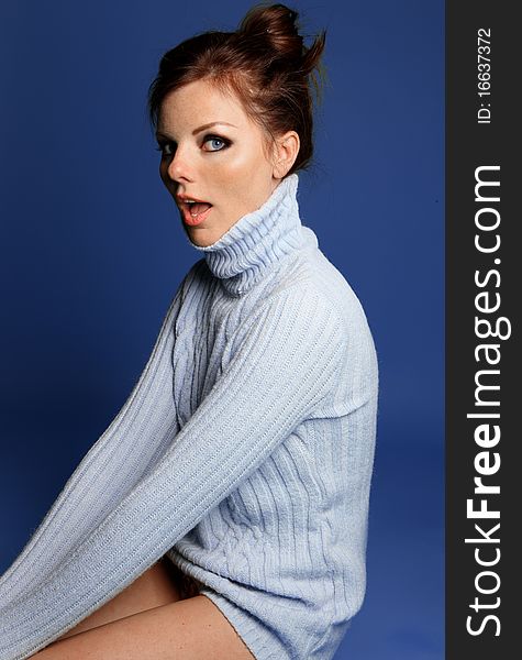 Sitting young woman in a blue sweater