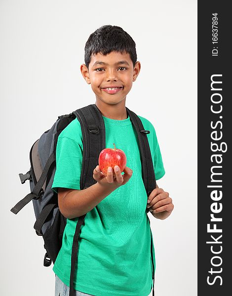 Young school boy wearing backpack, 10, with happy smile holding red apple. Studio shot against white background - Canon 5D MKII. Young school boy wearing backpack, 10, with happy smile holding red apple. Studio shot against white background - Canon 5D MKII