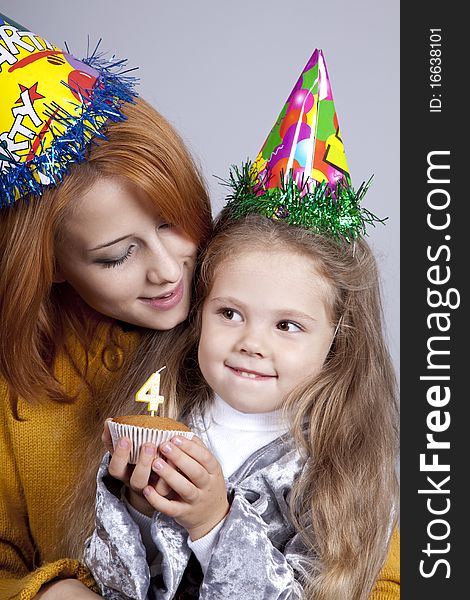 Two sisters four and eighteen years old at birthday. Studio shot.