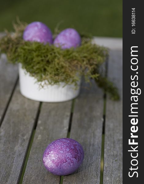 Easter eggs in purple lying on the table outdoor