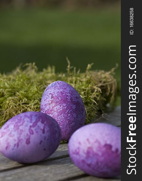 Three purple eggs lying on a table