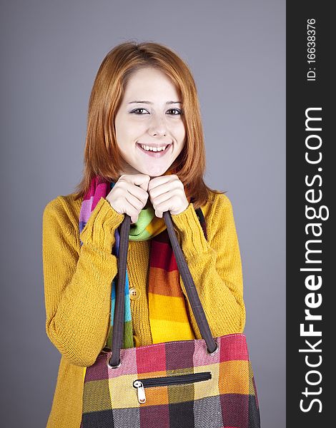 Portrait of red-haired girl in scarf. Studio shot.